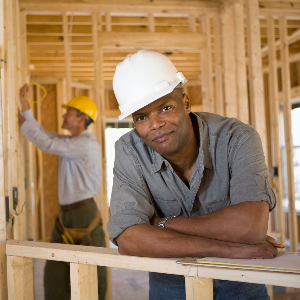 Contractor and employee in framed house